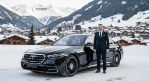 Experience unparalleled luxury with our Gstaad limousine service: a modern black sedan through Gstaad's breathtaking winter landscape.